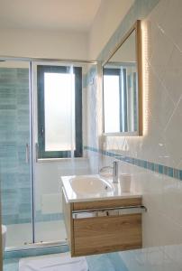bagno con lavandino, doccia e specchio di Magico Apartments - 450m dalla spiaggia a Capo dʼOrlando