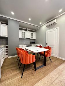 cocina con mesa y sillas de color naranja en Gagarin Plaza Stylish Apartment en Odesa