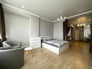 1 dormitorio con 1 cama y 1 silla en Gagarin Plaza Stylish Apartment, en Odessa