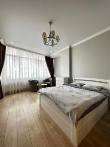 Un dormitorio con una cama grande y una lámpara de araña. en Gagarin Plaza Stylish Apartment en Odesa