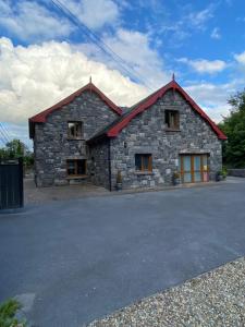 a stone house with a red roof at Salmon Weir Lodge in Cong