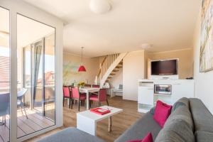 een woonkamer met een bank en een tafel bij Hotel Deichkrone - Familotel Nordsee in Norddeich