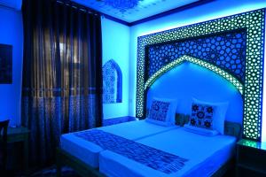a bedroom with a bed with a blue lighting at Khiva Tosh Darvoza in Khiva