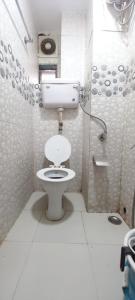 a small bathroom with a toilet and a shower at Hotel Janata in Mumbai