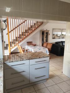 a kitchen with a counter top and a staircase at Hartenbos huisie in Hartenbos