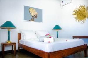 - une chambre avec un grand lit et deux lampes dans l'établissement Résidence Riziq villa 2, à Nosy Be
