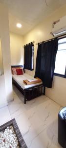 a small room with a bed and a window at Hotel Janata in Mumbai