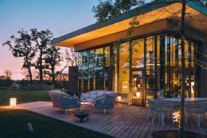 Le Bois d’Alice في Chanoz-Châtenay: فناء فيه كراسي وطاولات ومبنى