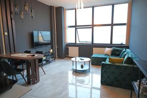 a living room with a couch and a table at Diamond Apartments Niš in Niš
