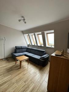 a living room with a blue couch and a table at Apartamenty Firfas Rodzinny 11 in Bydgoszcz