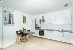 uma cozinha com armários brancos e uma mesa e cadeiras em Adrich Properties Gallery em Acra