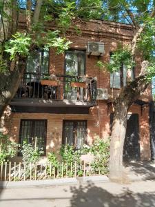 un edificio de ladrillo con un árbol delante de él en Sunflower Hotel, en Tiflis