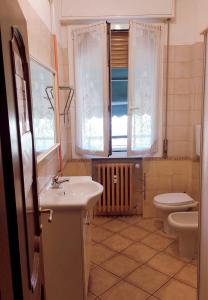 een badkamer met een wastafel, een toilet en een raam bij Euro House in Modena