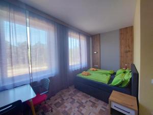 a bedroom with a bed with a green blanket on it at Wesendorf Residenz Premium Lounge in Wesendorf