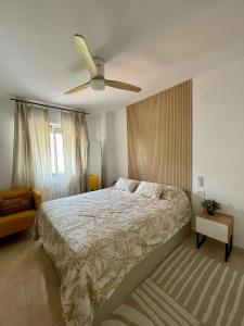 - une chambre avec un lit et un ventilateur de plafond dans l'établissement Bonito apartamento en la playa, à Benicàssim