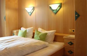 a bedroom with a bed with green and white pillows at Ferienapart Bergstille in Längenfeld