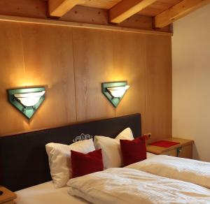 - une chambre avec un lit et deux lumières au-dessus dans l'établissement Ferienapart Bergstille, à Längenfeld