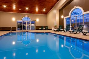 a swimming pool in a hotel with chairs and windows at Grandstay Hotel & Suites in Waunakee