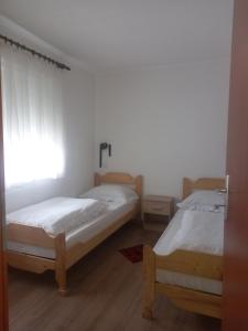 2 Betten in einem Zimmer mit Fenster in der Unterkunft Apartment Reni in Sarajevo