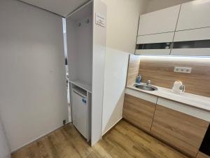 a small kitchen with a sink and a mirror at Szeged D&oacute;m-Sellőh&aacute;z Apartman in Szeged