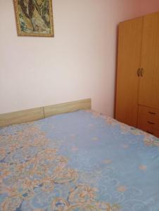 a bedroom with a bed with a blue blanket at City Center Cozy Apartment Tigran Mets in Yerevan