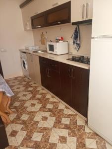 a kitchen with a refrigerator and a sink and a microwave at City Center Cozy Apartment Tigran Mets in Yerevan