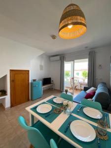 a living room with a table and blue chairs at Apartamento Sa Farola in Cala en Blanes