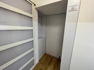 a walk in closet with white walls and wooden floors at Szeged D&oacute;m-Sellőh&aacute;z Apartman in Szeged