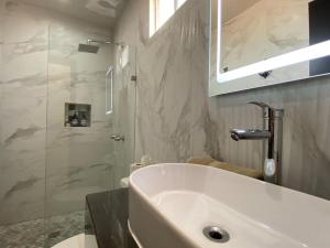 a white bathroom with a sink and a shower at Ancla Suite 9 - Urban Hotel in Puerto Peñasco