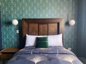 a bedroom with a bed with a green patterned wall at Ancla Suite 9 - Urban Hotel in Puerto Peñasco