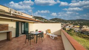 Un patio con una mesa y sillas en un balcón. en Magico Apartments - 450m dalla spiaggia, en Capo dʼOrlando