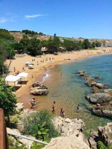 una playa con un montón de gente en el agua en casa S Leonardo en Crotone