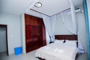 Lubowa View Apartments في كامبالا: غرفة نوم بسرير كبير مع باب احمر