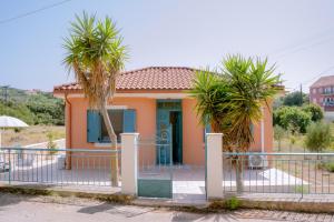 una casa con palmeras delante en Abuelita Cottage, en Andipáta Erísou