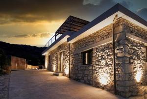 a stone building with lights on the side of it at Pool Villa Leonidas Crete in Stíronas