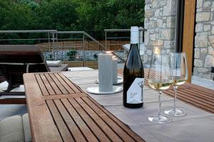 a table with a bottle of wine and two glasses at Pool Villa Leonidas Crete in Stíronas