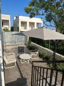 une terrasse avec une table, des chaises et un parasol dans l'établissement LaMarticata-LikesHome StreetView, à Triscina