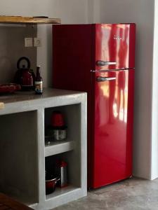 a red refrigerator in a kitchen next to a counter at Cave Beach House Milos in Provatas