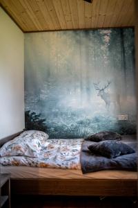 a bedroom with a wall with a painting of a deer at Bieszczadzka Miejscówka in Lutowiska