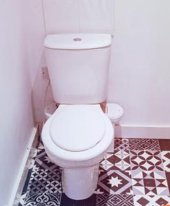 a white toilet in a bathroom with black and white tiles at The Cosy Beach in Llanelli