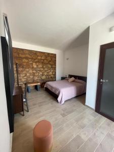 1 dormitorio con cama y pared de piedra en Ristorante Bar Fittacamere Le BISTROT, en Sonnino