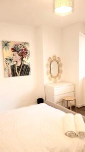 ロンドンにある2 Bedroom Apartment in Regents Parkのベッドルーム1室(ベッド1台付)が備わります。壁には絵画が飾られています。