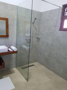 um chuveiro com uma porta de vidro na casa de banho em Tortuga Beach Hotel em Paiyagala South