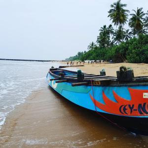 um barco azul sentado na costa de uma praia em Tortuga Beach Hotel em Paiyagala South