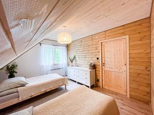 a bedroom with two beds and a wooden wall at ZaBieszczaduj - apartamenty do wynajęcia in Lutowiska