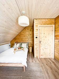 1 dormitorio con cama y techo de madera en ZaBieszczaduj - apartamenty do wynajęcia en Lutowiska