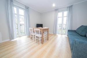 a living room with a table and a blue couch at VacationClub – Zdrojowa 7 Apartament 6 in Duszniki Zdrój