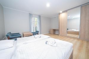 a bedroom with two beds and a large mirror at VacationClub – Zdrojowa 7 Apartament 6 in Duszniki Zdrój