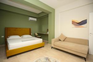 a bedroom with a bed and a couch and a chair at Seaside Apartments in Vlorë