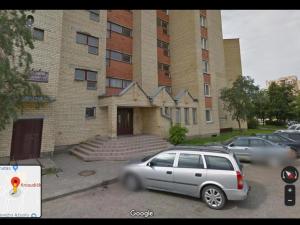 une voiture en argent garée devant un bâtiment dans l'établissement Viktorijos apartamentai, à Panevėžys